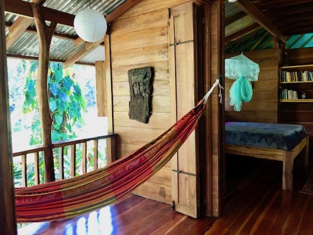a hammock in a room in a log cabin at Las Ranitas in Puerto Viejo