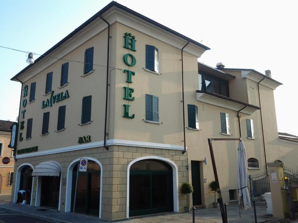 a building with a sign on the front of it at La Vela in Viadana