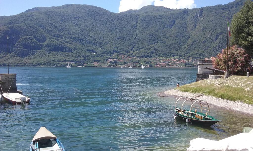 two boats are docked on the shore of a river at CASA LIBERTY in Mandello del Lario