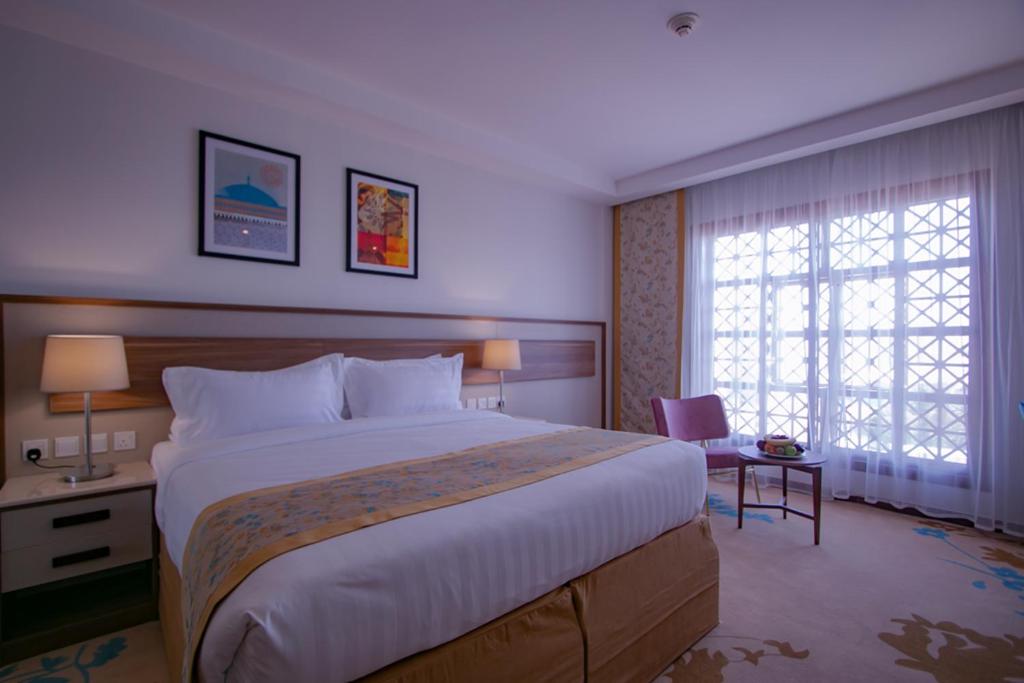 a hotel room with a large bed and a window at Le Bosphorus Hotel - Waqf Safi in Al Madinah