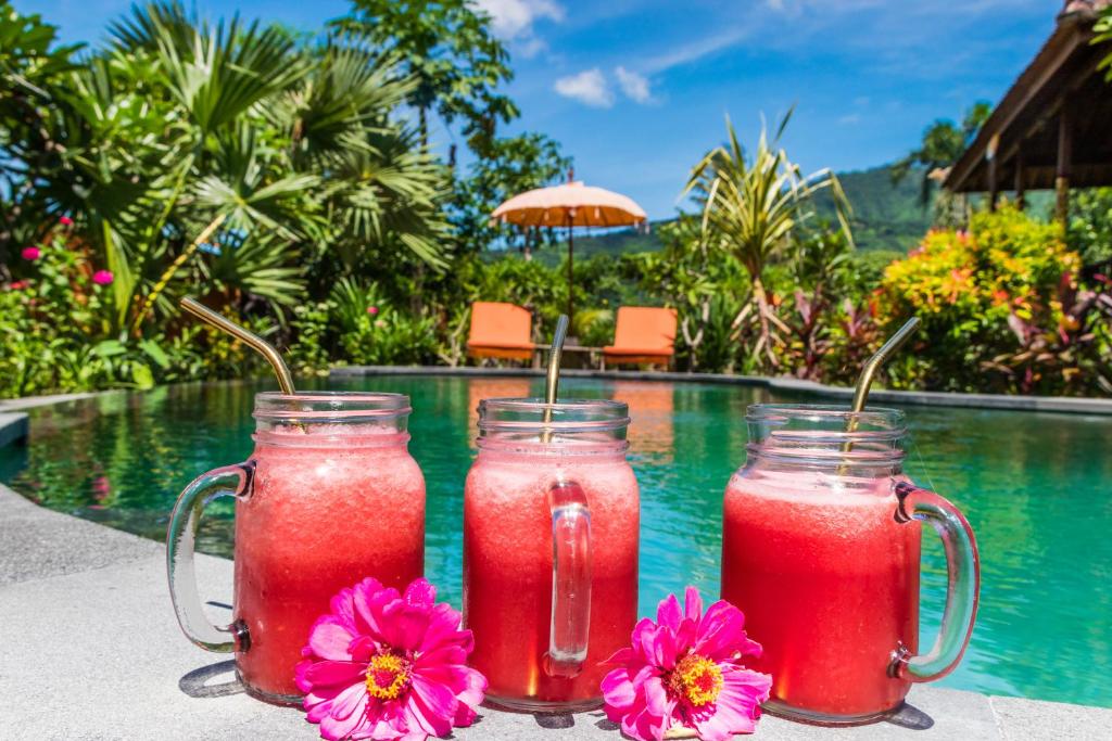 two drinks in mason jars next to a swimming pool at Villa Melasti Amed in Amed