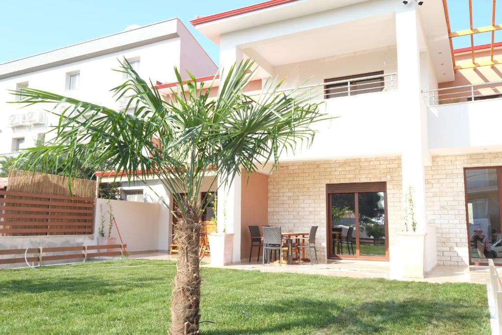a palm tree in front of a house at Villa Valerie in Nikiti