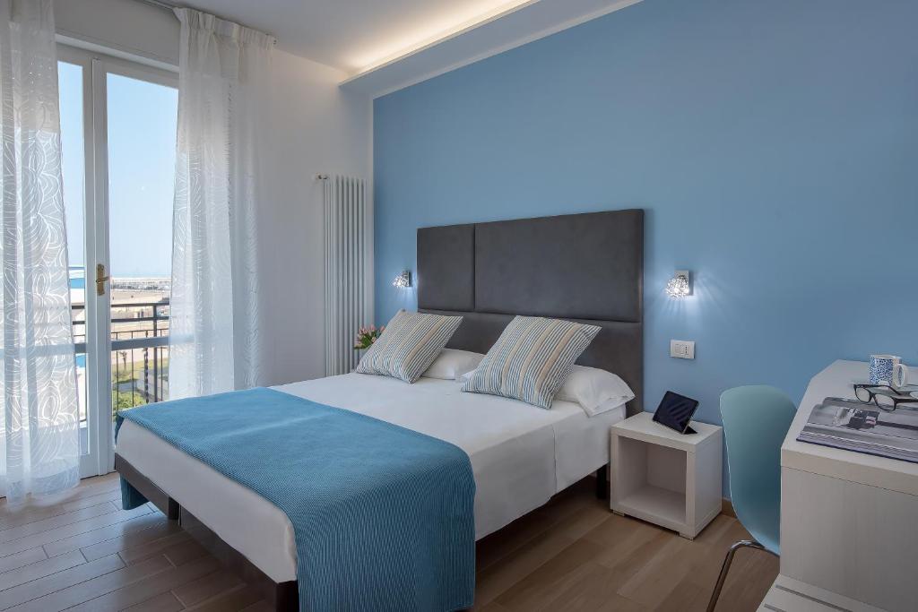 1 dormitorio con cama grande y ventana grande en Hotel Maria Serena en Rímini