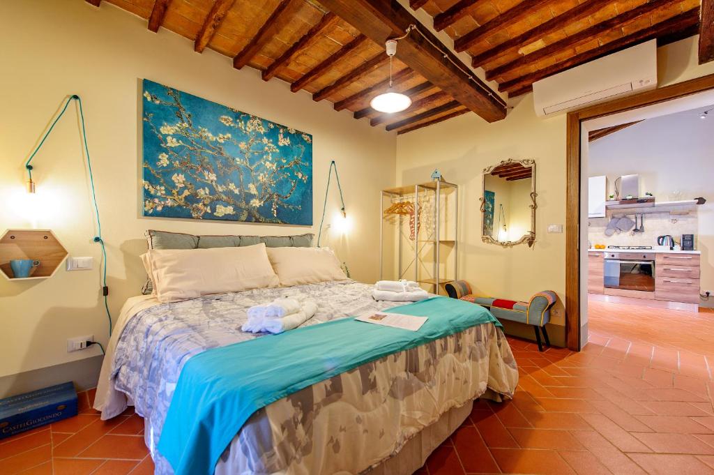 una camera da letto con un letto e un dipinto sul muro di Residenza d'Epoca La Rosa a Pienza