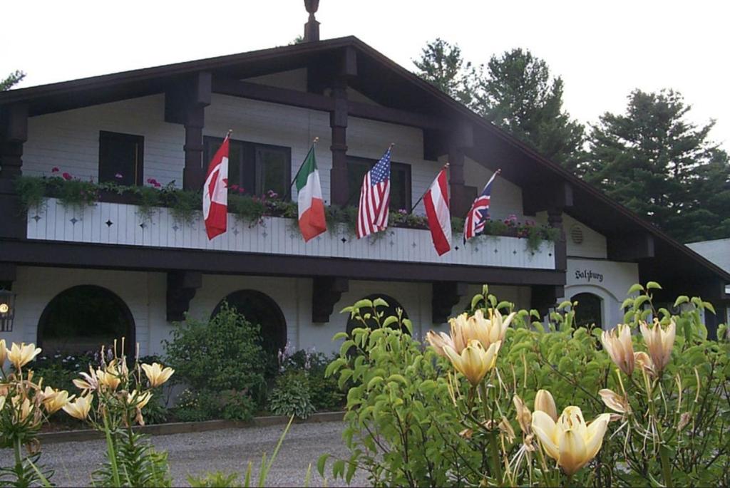 un grupo de banderas en un edificio con flores en Northern Lights Lodge, en Stowe