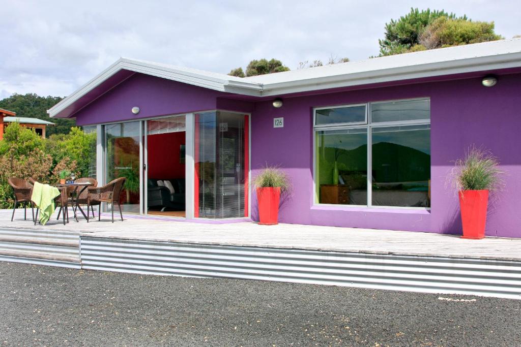 a purple house with potted plants on a porch at Sisters Beach Retreat in Sisters Beach