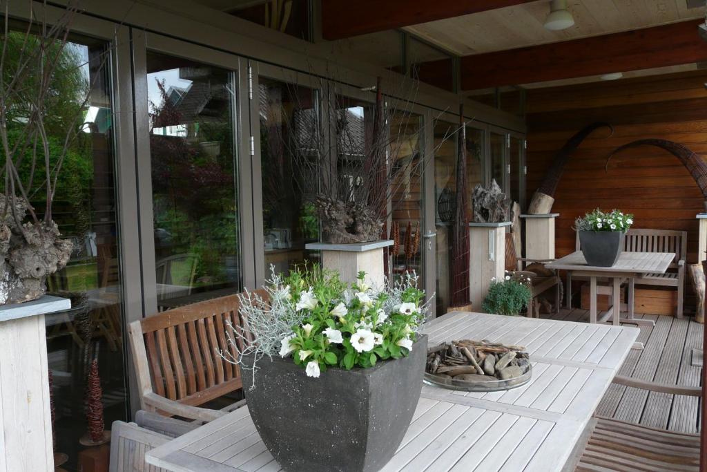 a porch with a table with flowers on it at Appartementen Het Oude Atelier in Schoorl