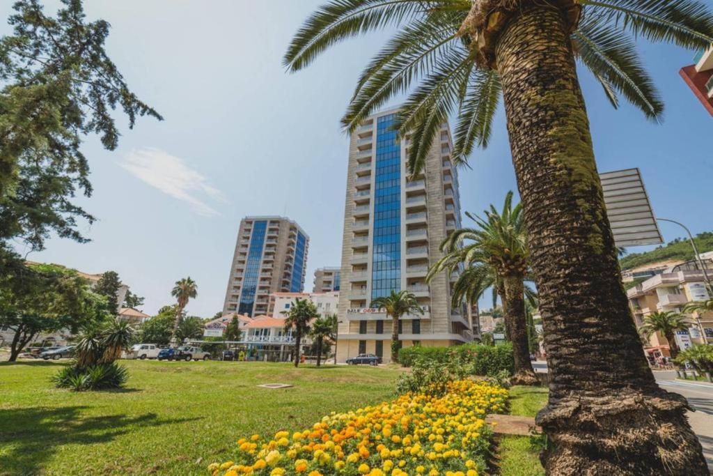 布德瓦的住宿－Blue Marlin Apartments，一座公园里的棕榈树和鲜花