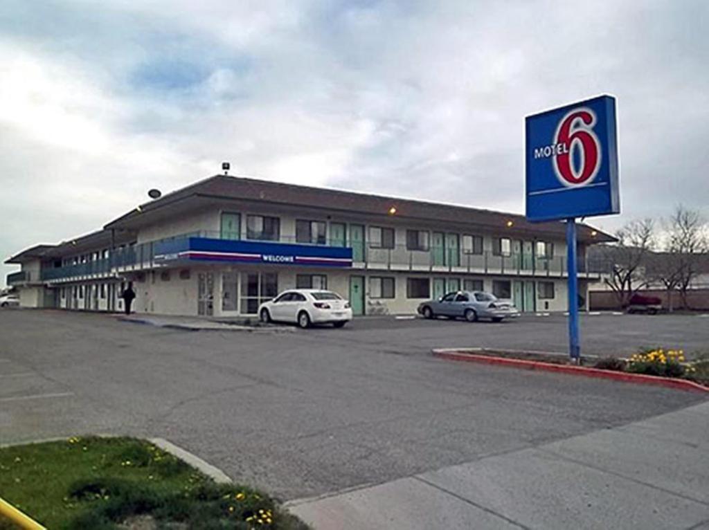 un edificio con coches estacionados en un estacionamiento en Motel 6-Ely, NV, en Ely