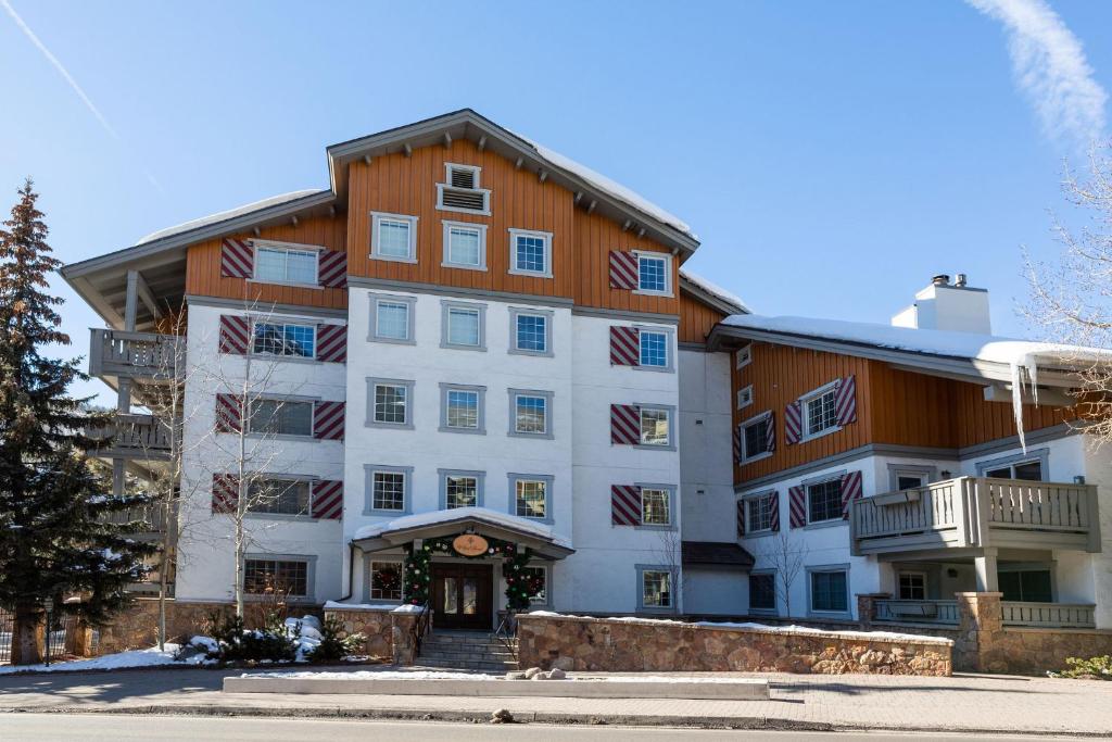 a large white building with flags on it at 9 Vail Road Vail Village 2 to 4 Bedrooms by Vail Realty in Vail