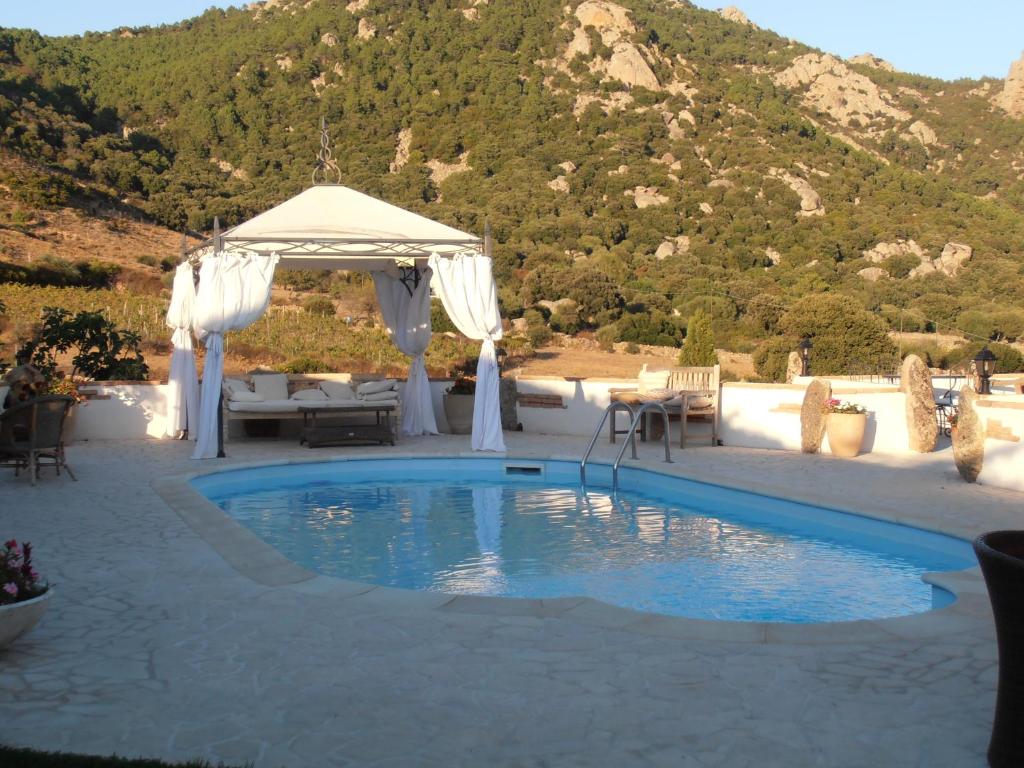 a pool with a gazebo and a table and chairs at Casa Alianda in Telti