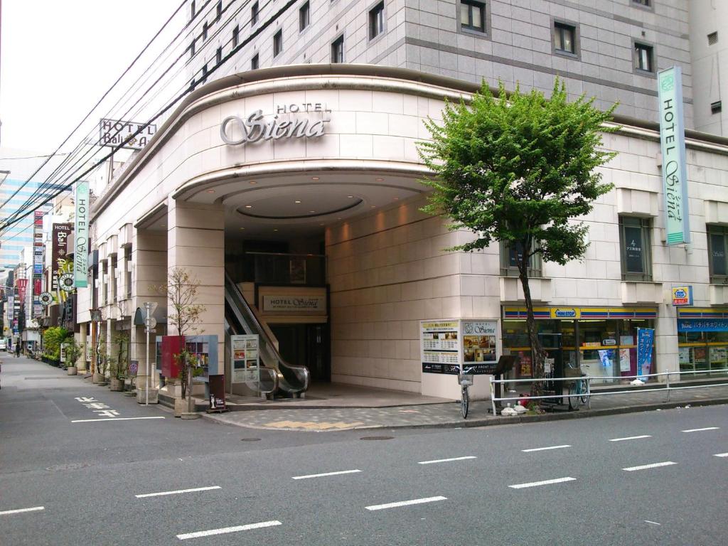 een winkel voor een gebouw in een stadsstraat bij Hotel Siena in Tokyo
