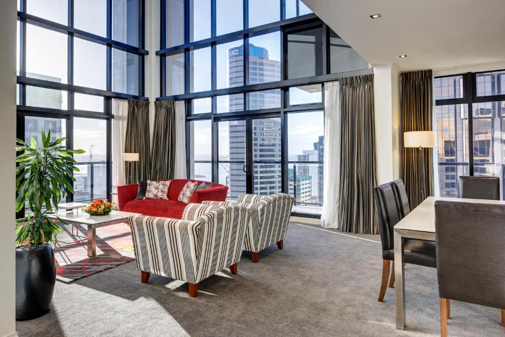 a living room with large windows and a red couch at CityLife Auckland in Auckland