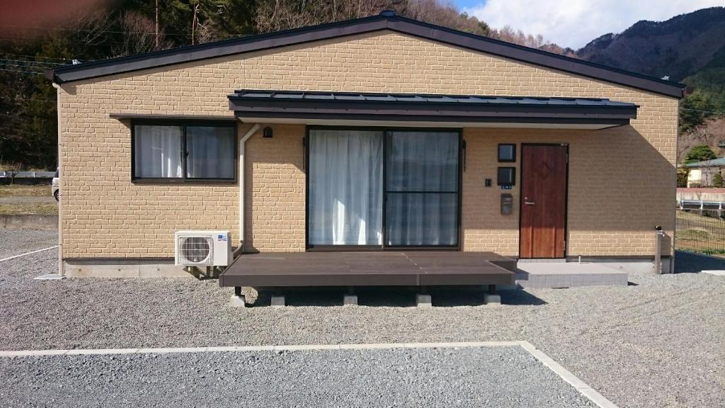 um pequeno edifício com um banco à frente em Cortege em Fujiyoshida