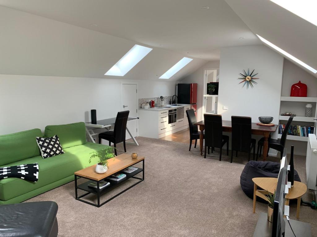 uma sala de estar com um sofá verde e uma mesa em 112 Rural View em Cambridge