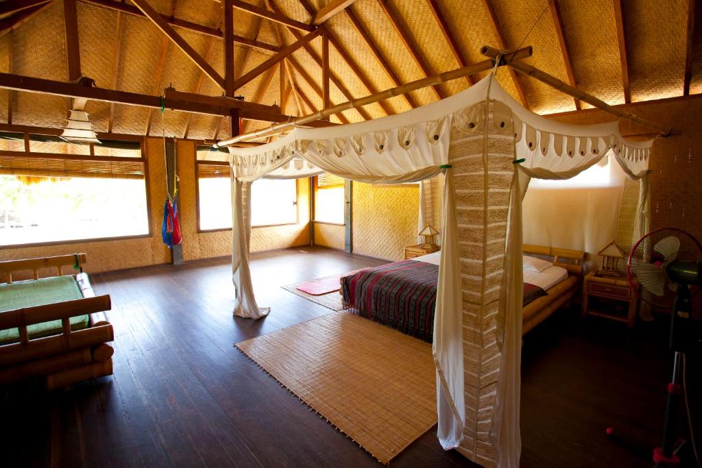 a bedroom with a canopy bed in a room at Malole Surf House in Nembrala