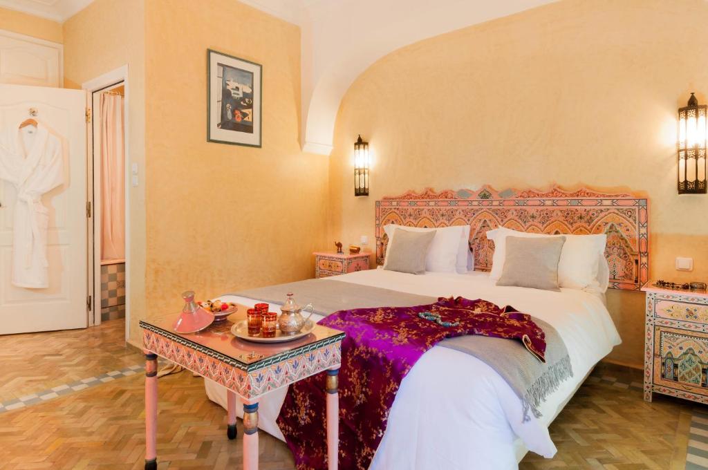 1 dormitorio con 1 cama grande y 1 mesa en Double room in a charming villa in the heart of Marrakech palm grove en Marrakech