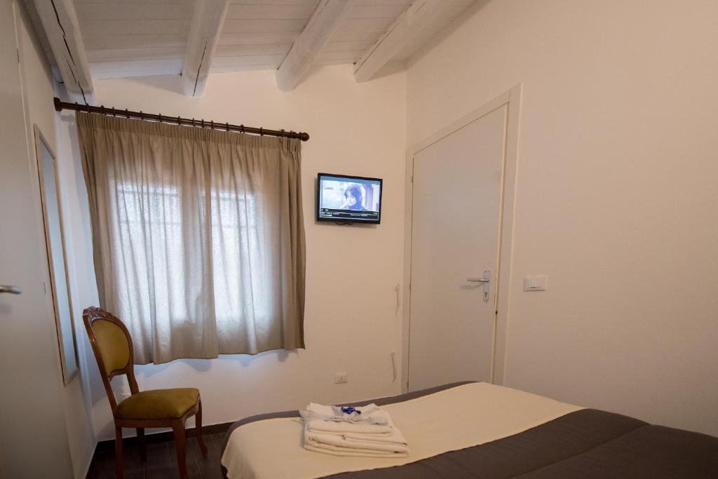 a bedroom with a bed and a tv on the wall at Camagna Country House - immersed in the Sicilian countryside in Partanna