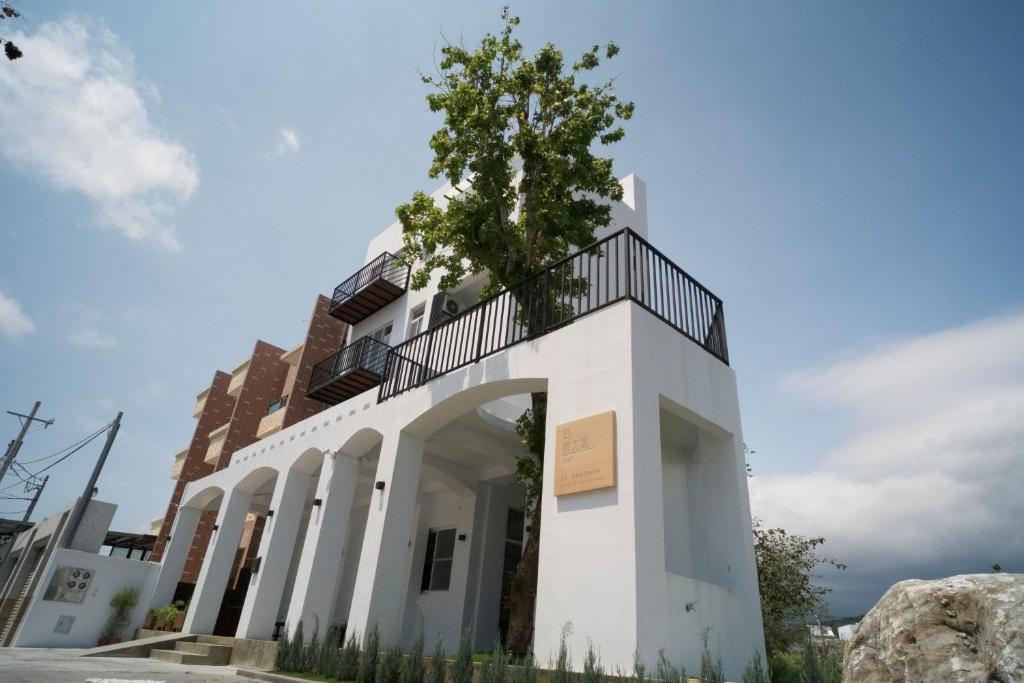 a white building with a tree on top of it at Lof/it in Taitung City