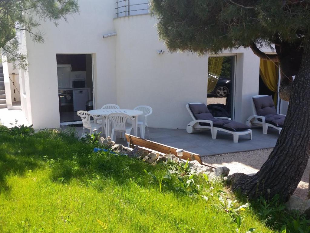 a patio with a table and chairs and a tree at Cap Negre villa in Six-Fours-les-Plages