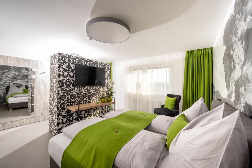a bedroom with a large bed and a television at Hotel Greenrooms in Graz