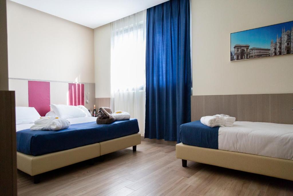 a hotel room with two beds and a window at iH Hotels Milano St. John in Sesto San Giovanni