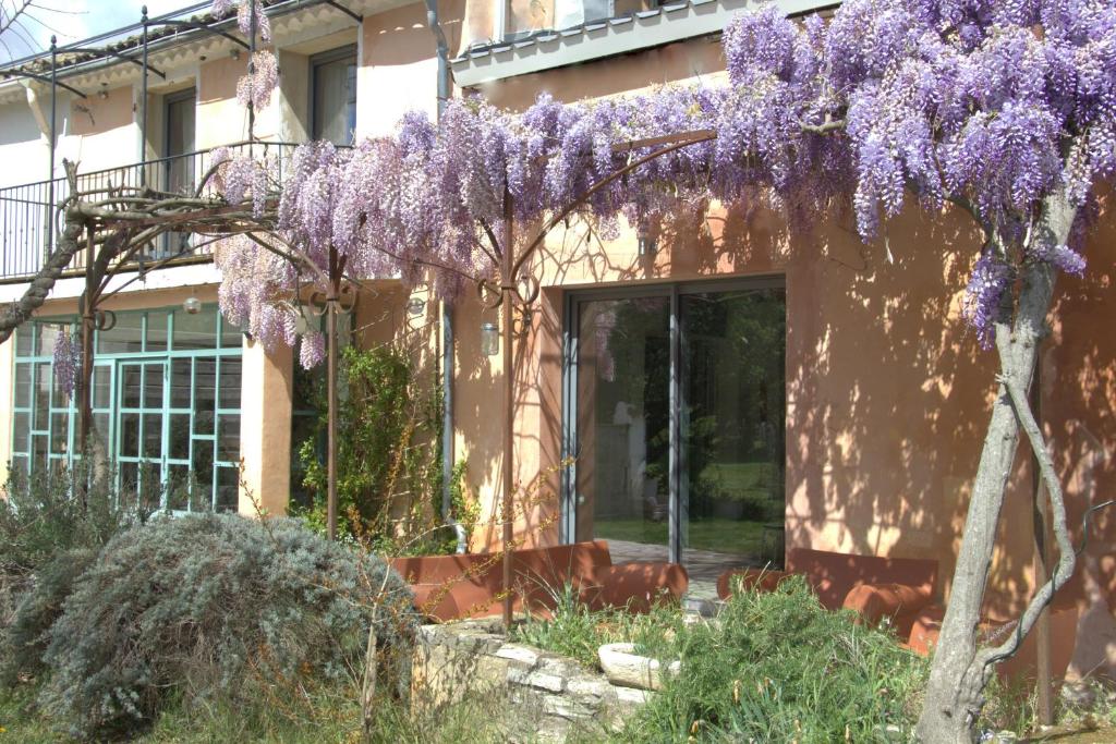 une maison avec des glycérines violettes sur son côté dans l'établissement Mas Du Petit Claux, à Barbentane