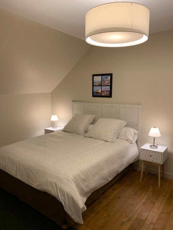 - une chambre avec un grand lit et un couvre-lit blanc dans l'établissement Appartement de 70 m2 bien situé à Boulogne sur mer, à Boulogne-sur-Mer