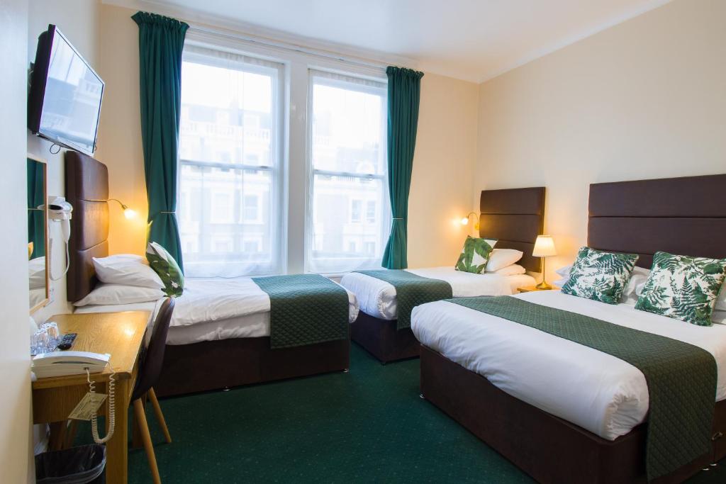 um quarto de hotel com duas camas e uma televisão em London Town Hotel em Londres