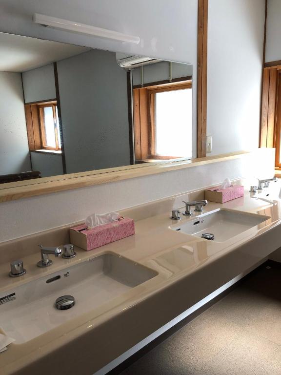 a bathroom with two sinks and a large mirror at Oyado Zen in Kusatsu