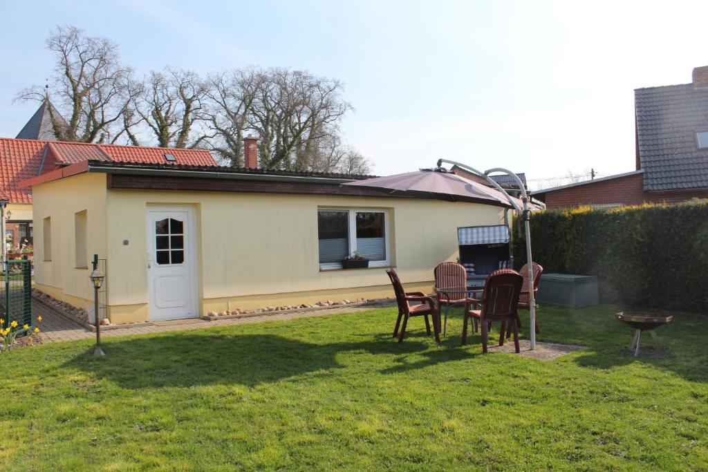 a yard with chairs and a table and a house at Bungalow Groß Dratow in Groß Dratow
