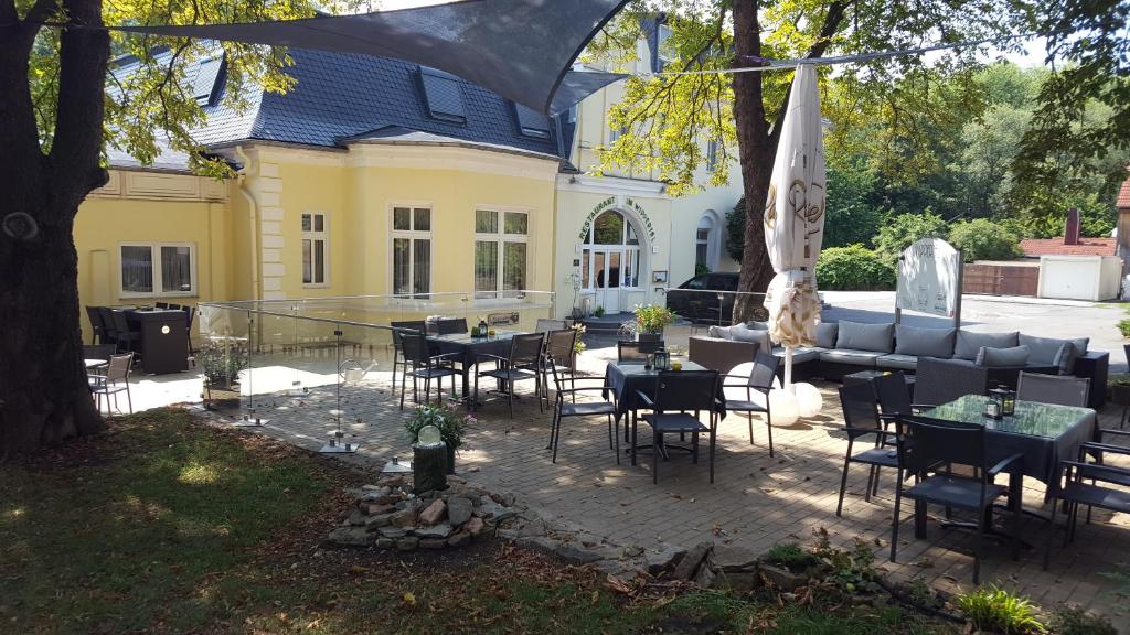 a patio with tables and chairs in front of a building at Hotel Wippertal in Bernburg