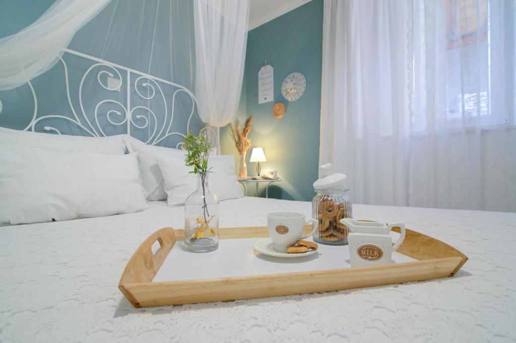 a tray with two cups and a tea set on a bed at Dida moj in Senj
