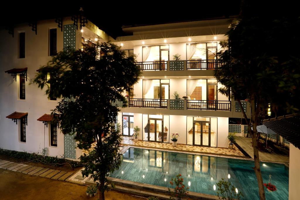un edificio con piscina frente a él en Tropical Garden & Pool Villa, en Hoi An