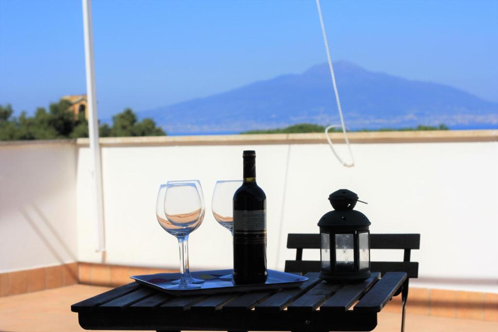 butelkę wina i kieliszek na stole w obiekcie Casa Bice Amazing view of Vesuvius with Pool w Sorrento