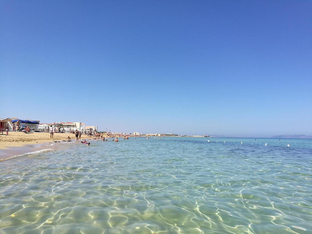 a beach with a bunch of people in the water at Casa Vacanza Albamarina in Trapani