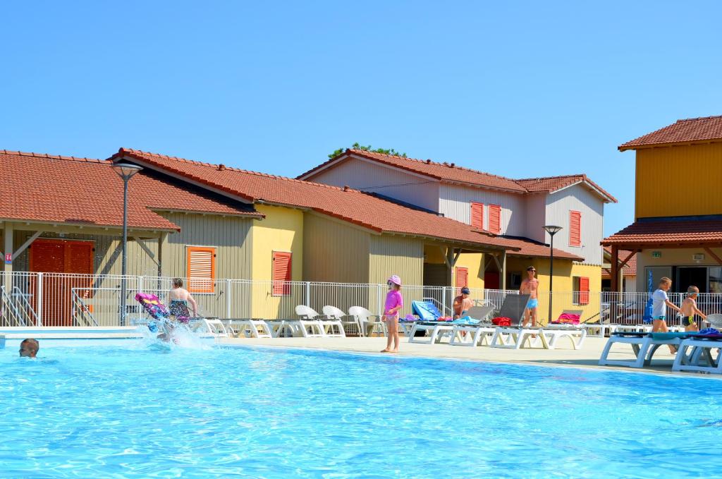 a group of people playing in a swimming pool at Lagrange Grand Bleu Vacances – Résidence La Grenadine in Marseillan