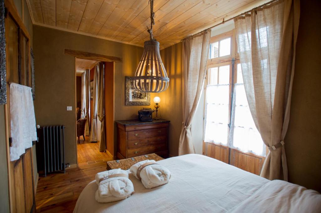 1 Schlafzimmer mit 2 Handtüchern auf einem Bett mit Fenster in der Unterkunft Le Rêve d'Aghon Chambres et Table d'Hôtes in Bagnères-de-Bigorre