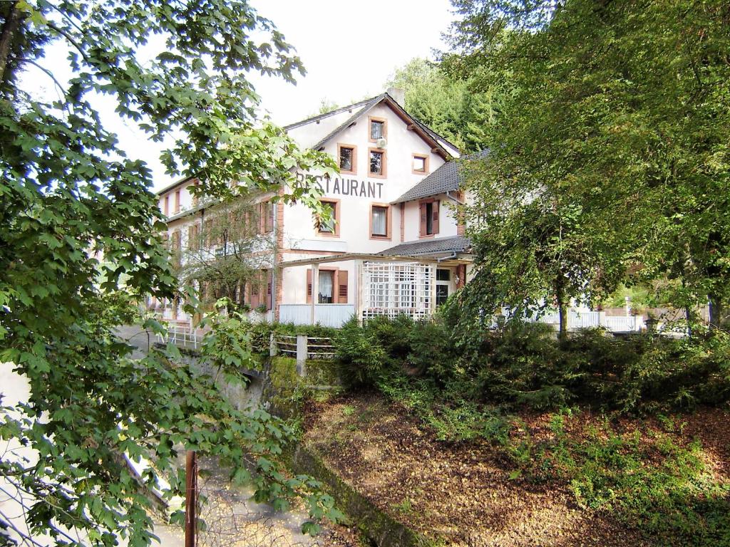 - un grand bâtiment blanc avec un panneau dans l'établissement Auberge Des Mésanges, à Meisenthal