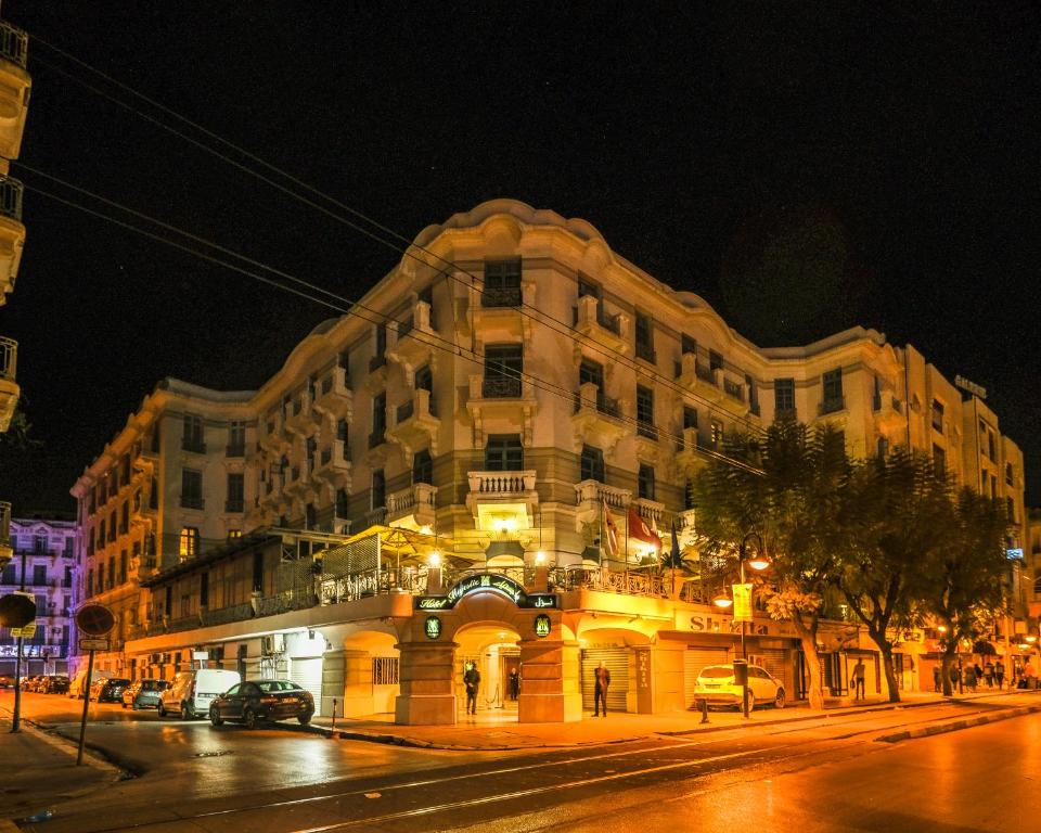 a large building on a city street at night at Majestic Hotel in Tunis
