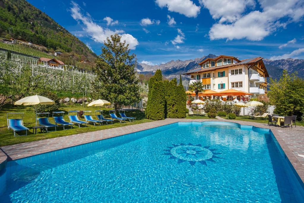 a pool at a hotel with mountains in the background at Landhaus Hotel Kristall in Marlengo