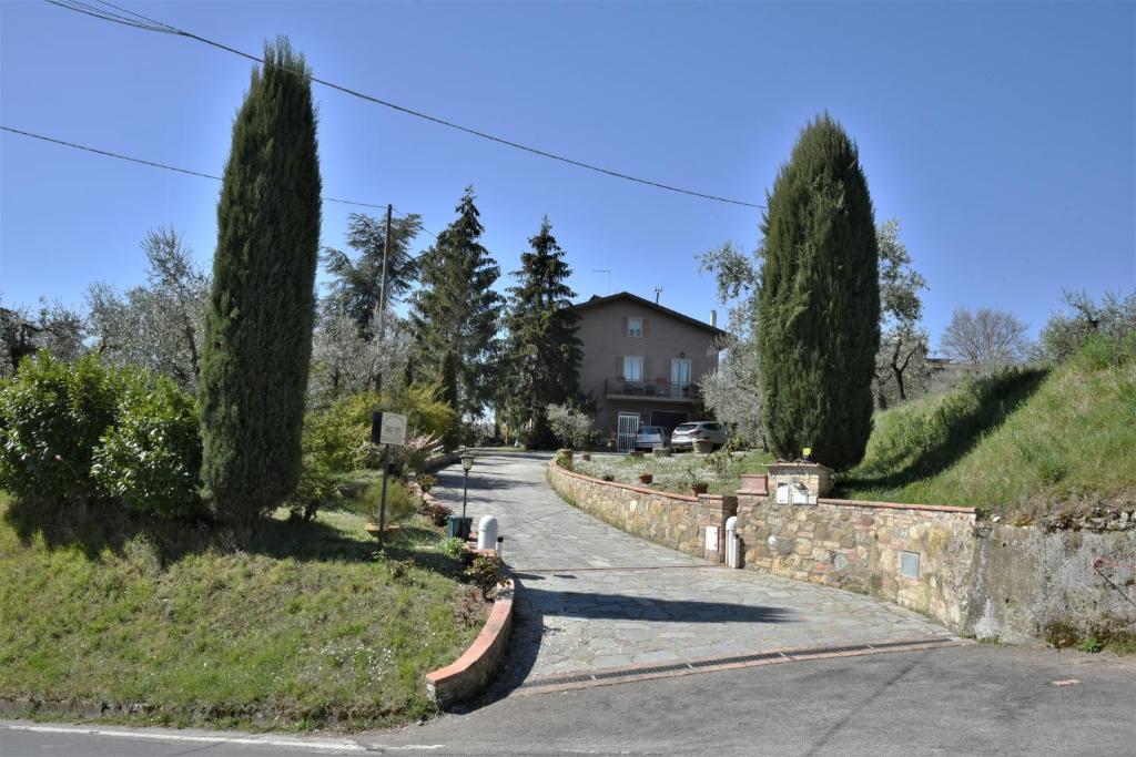 a road with trees and a house in the background at Agriturismo Campo Contile in Chianciano Terme