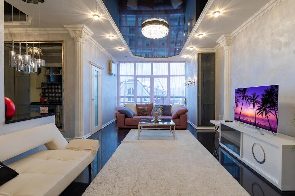 a living room with a couch and a tv at Botanic Towers in Kyiv