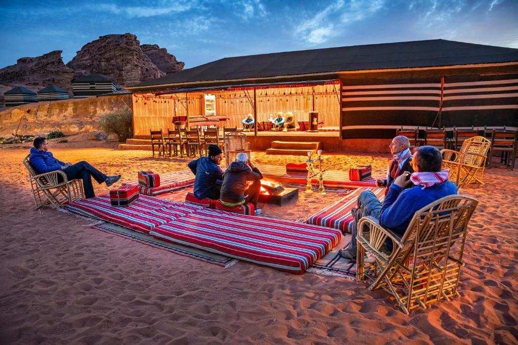 un gruppo di persone seduti sulle sedie di fronte a un edificio di Mohammed Mutlak Camp a Wadi Rum