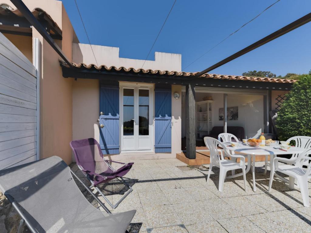 une terrasse avec une table et des chaises ainsi qu'une maison dans l'établissement Holiday Home Colline Valmer-3 by Interhome, à La Croix-Valmer