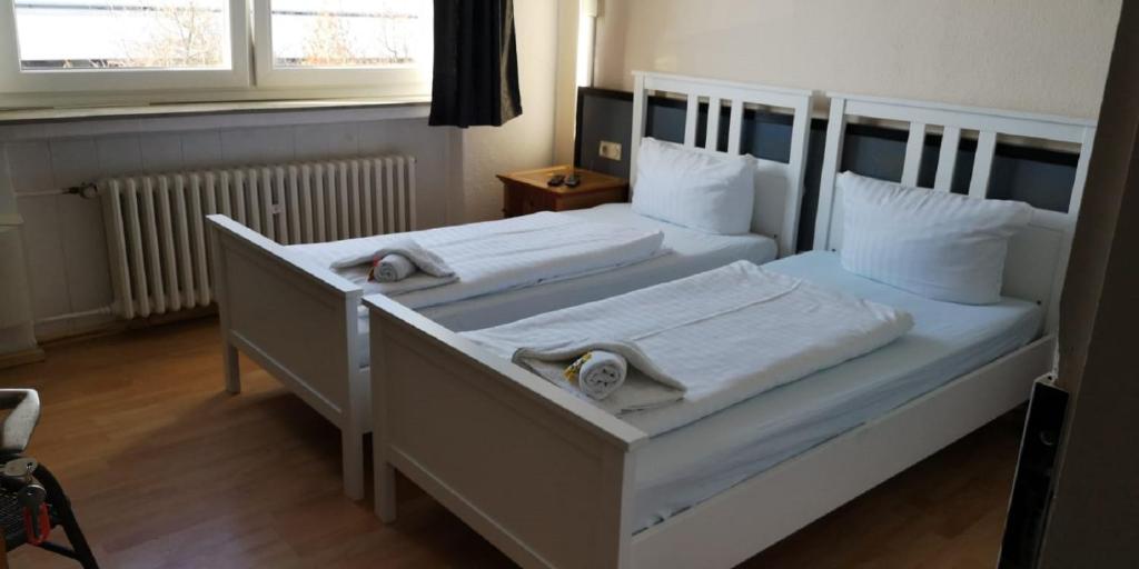 two beds in a hotel room with white furniture at GZ Hostel Bonn in Bonn