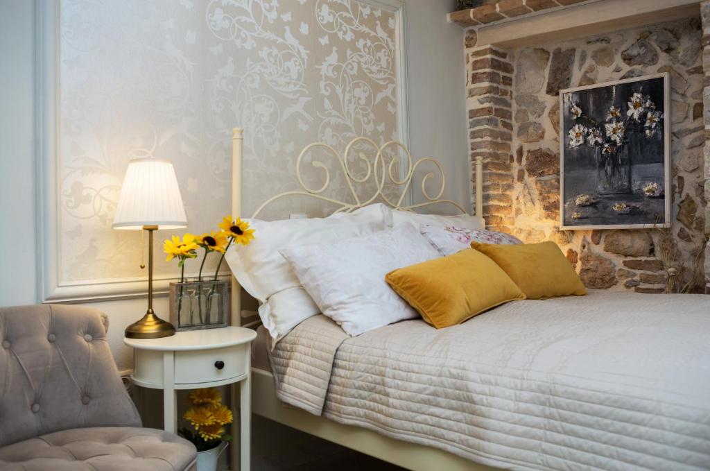 een slaapkamer met een bed, een stoel en een lamp bij Studio Yellow Flower in Rovinj