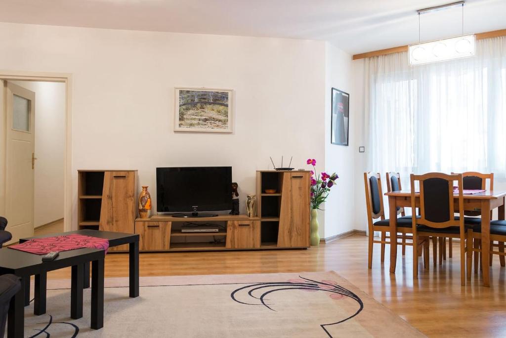 sala de estar con TV, mesa y sillas en GLORIOUS - 2-Bedroom apartment near Youth Hill, en Plovdiv