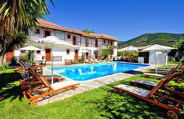 una casa con piscina con sillas y sombrillas en Marigoula Village, en Skopelos Town
