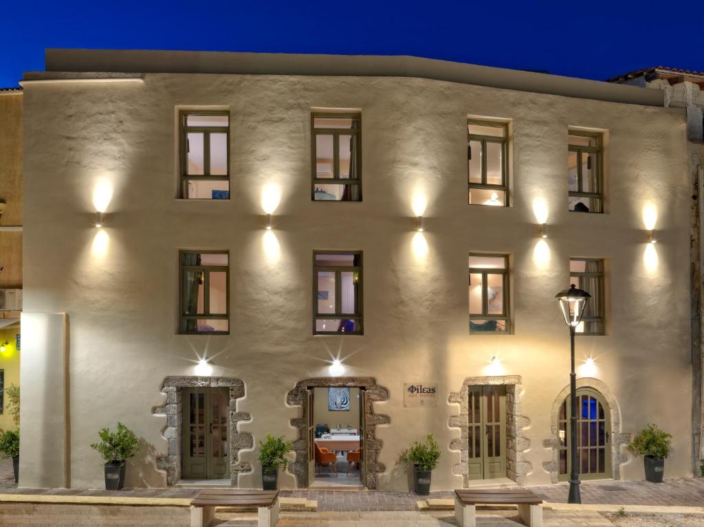 a large white building with benches in front of it at Fileas Art Hotel in Chania